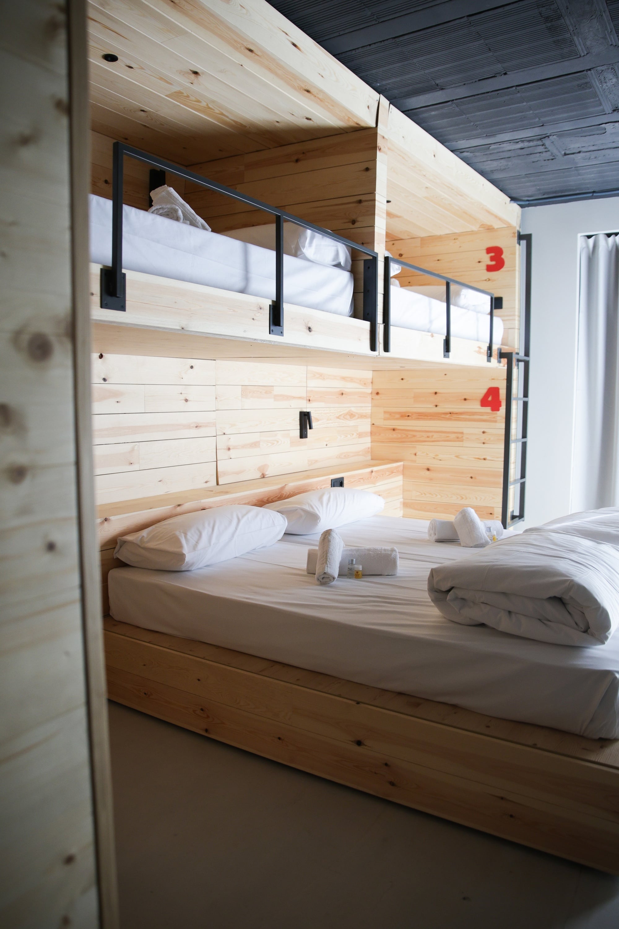 una habitación con literas de madera y las números 34 y 12