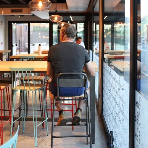 un home està sent en una silla en un restaurant