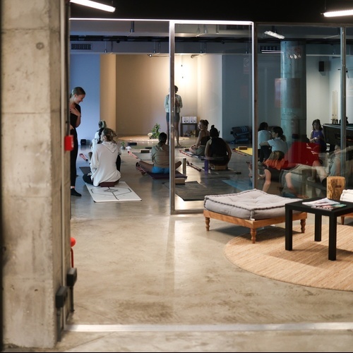 un grup de persones està sentant-se en ioga en un saló