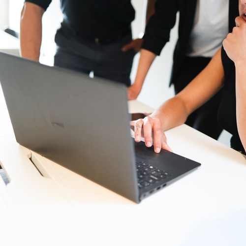 un grup de persones mirant un ordinador portàtil