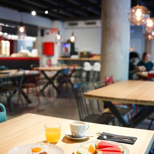 una mesa con platos de comida y un vaso de zumo de naranja