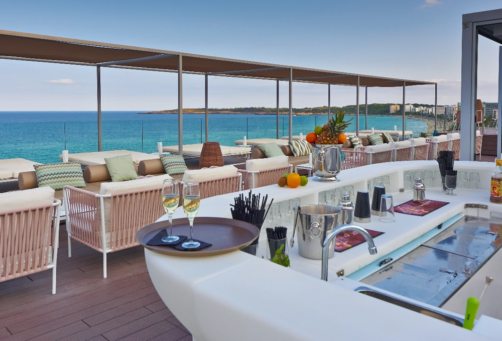 una bebida roja con una pajita en la playa