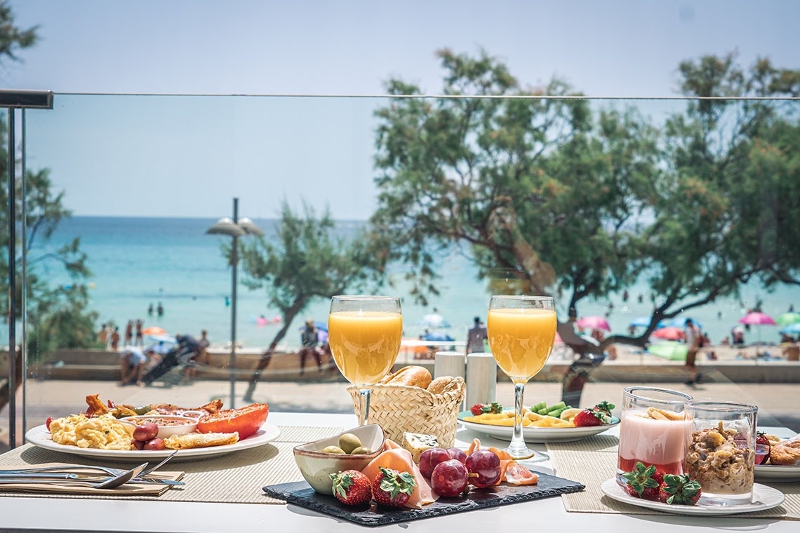 una bebida roja con una pajita en la playa