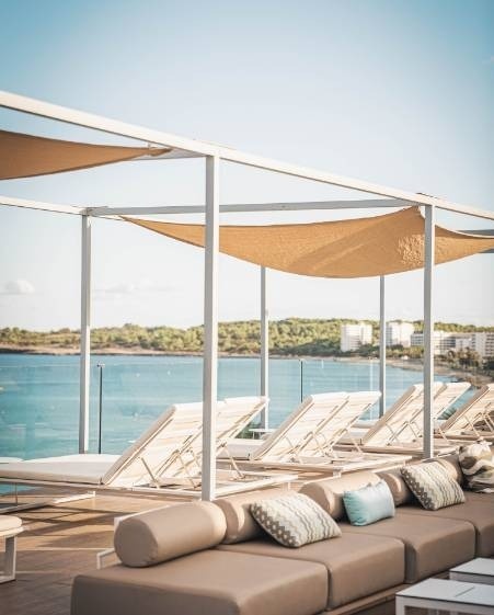 una terraza con sillas y sofás con vistas al océano