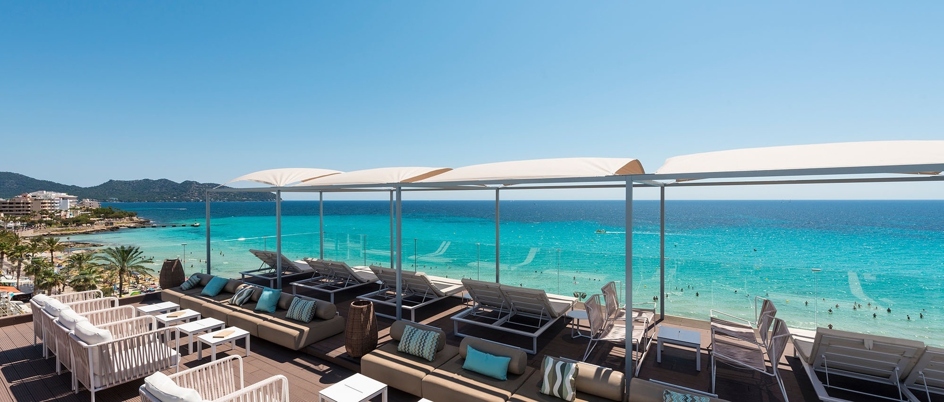 une terrasse avec des chaises et des canapés avec vue sur l' océan