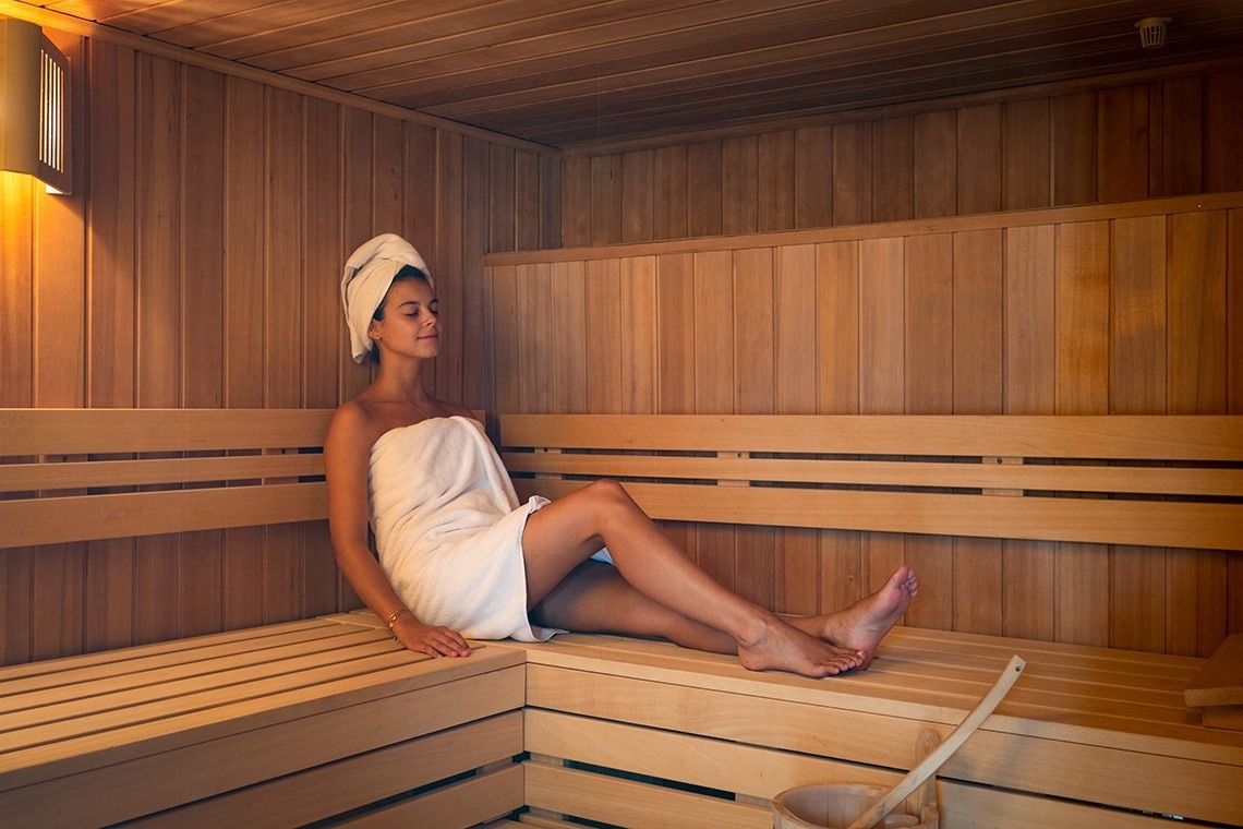 una bebida roja con una pajita en la playa