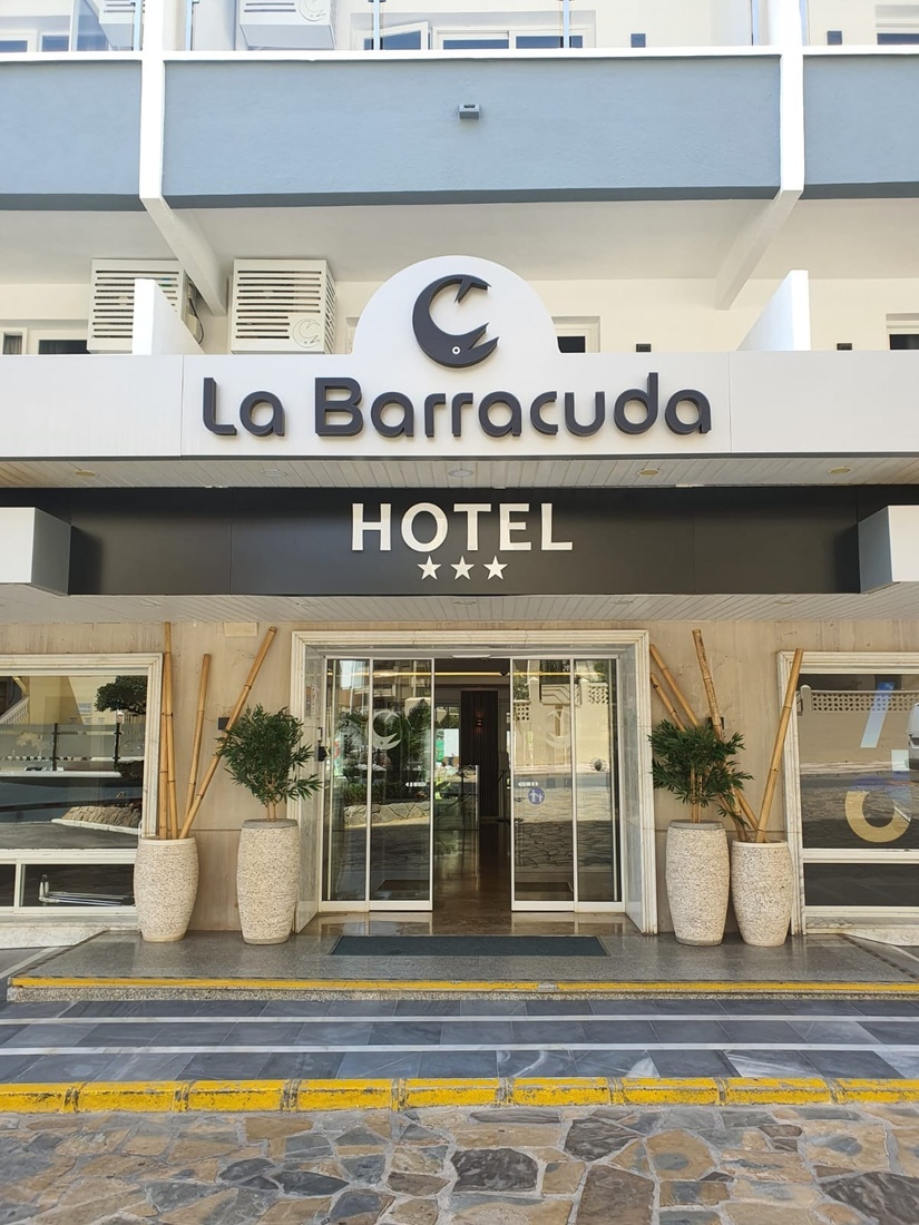 the entrance to the la barracuda hotel has a sliding glass door