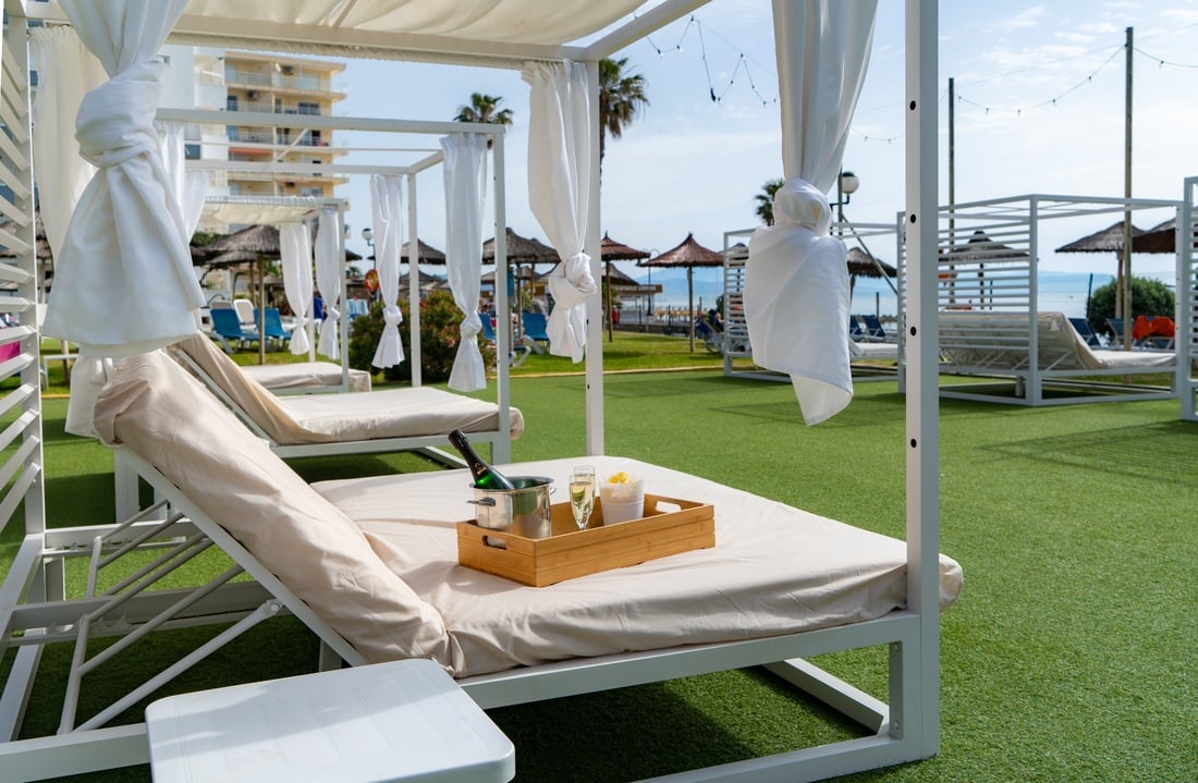 Camastros de lujo con champagne y vistas al mar en Barracuda Beach Resort.