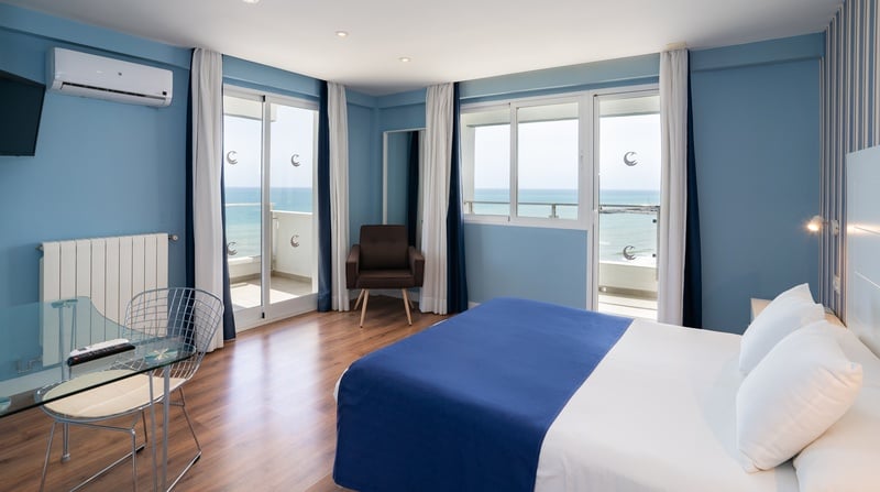 una habitación con una cama y una televisión con vista al océano