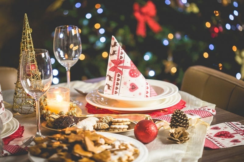 a table set for a christmas dinner with a napkin that says ' christmas ' on it