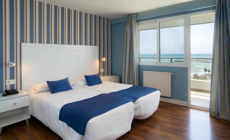 una habitación con dos camas y una ventana con vista al océano