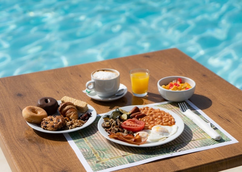 a table with plates of food and a napkin with the letter c on it