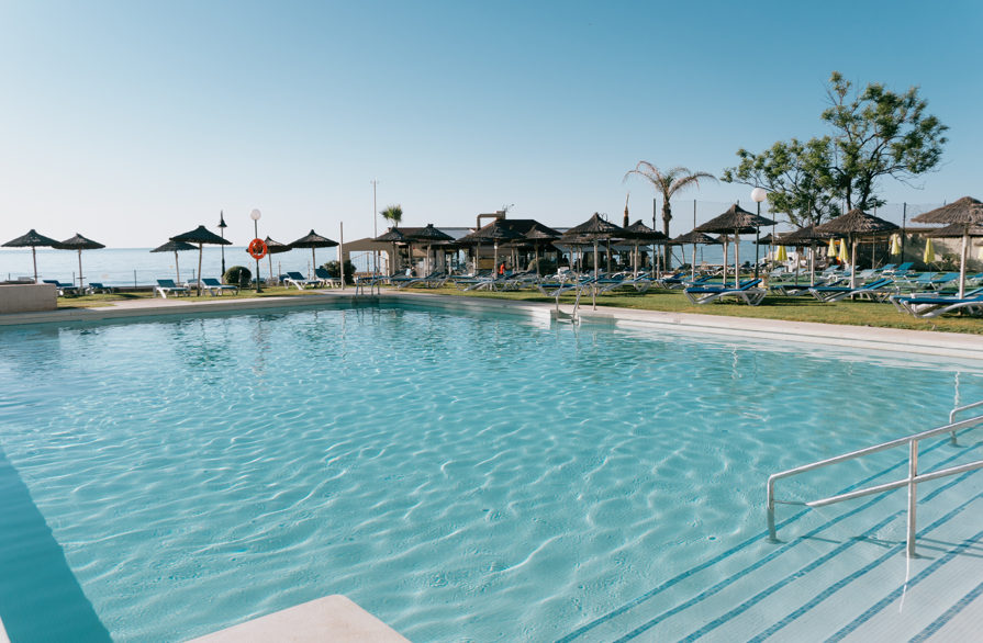 a large swimming pool surrounded by umbrellas and chairs