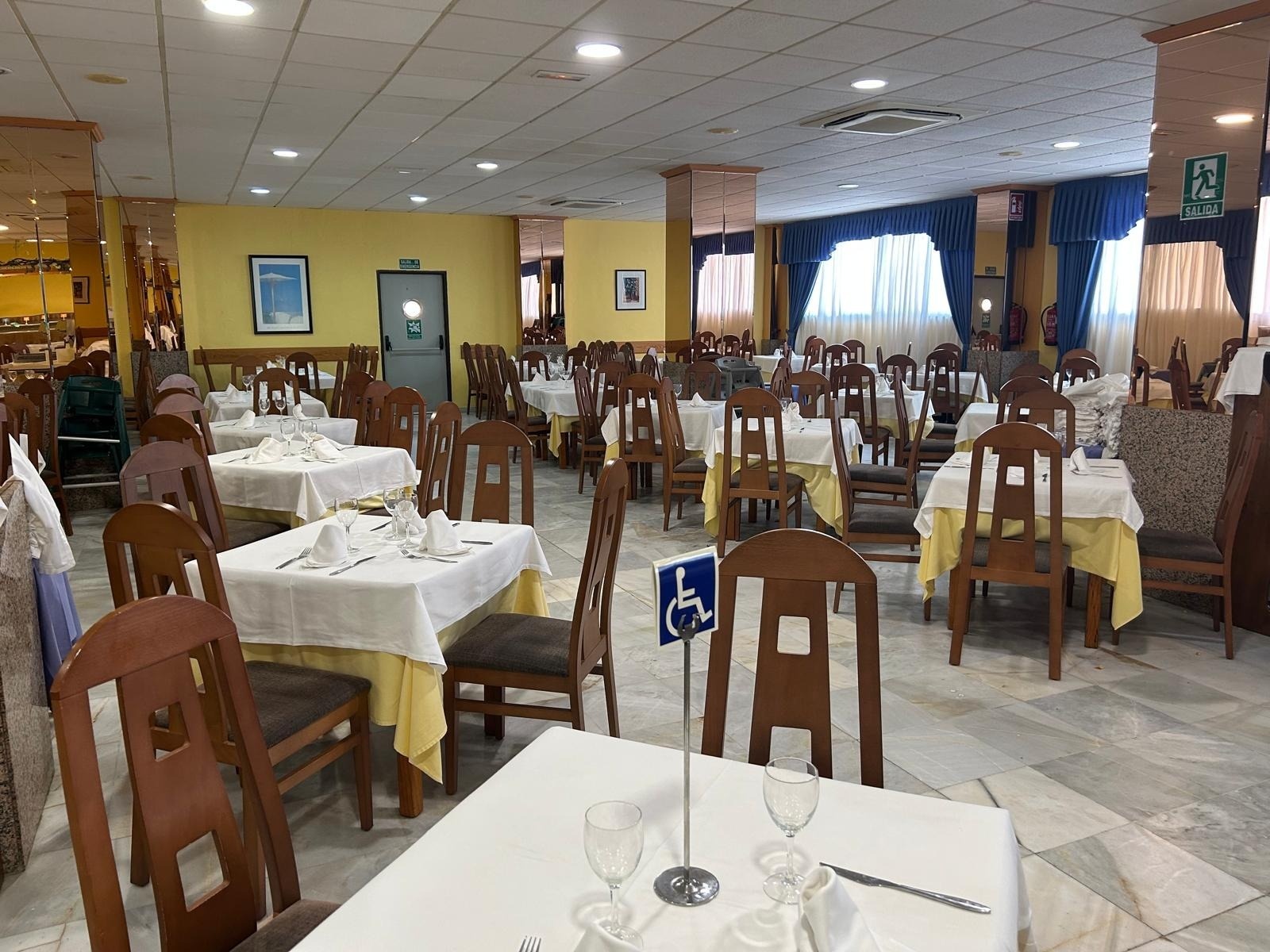 a restaurant with tables and chairs and a handicap sign