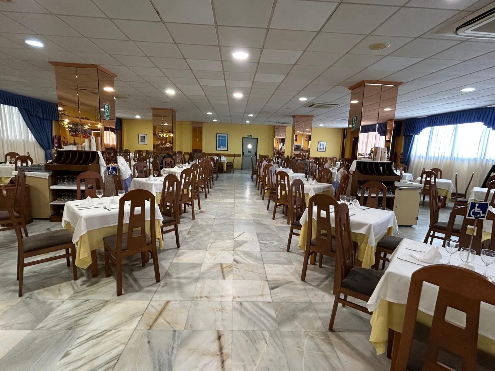 a dining room with tables and chairs and a handicap sign
