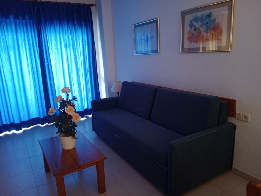 a living room with a table and chairs and a flat screen tv