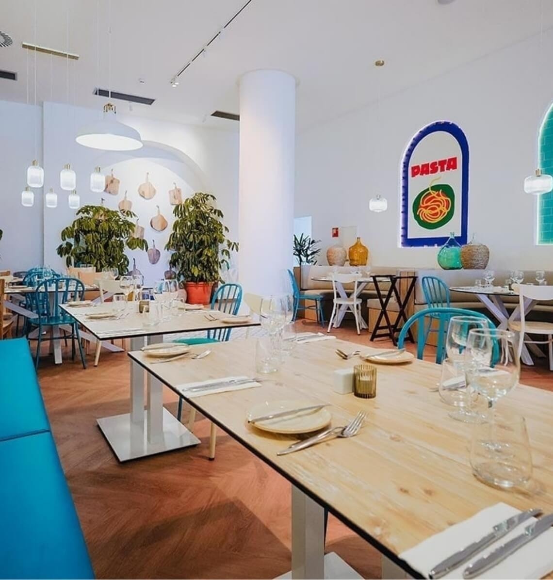 Modern Landmar restaurant featuring wooden tables and blue chairs.