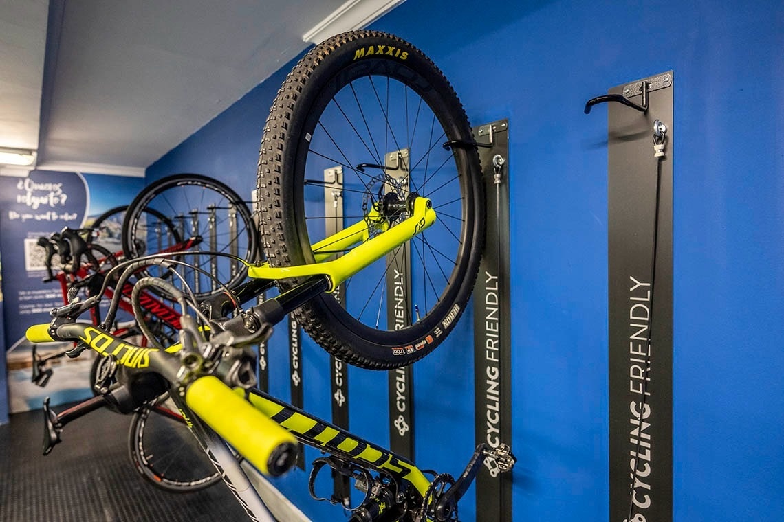 una bicicleta amarilla está colgada en una pared azul