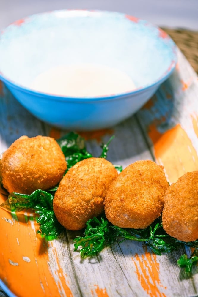 un plato de comida con un tazón de salsa en el fondo