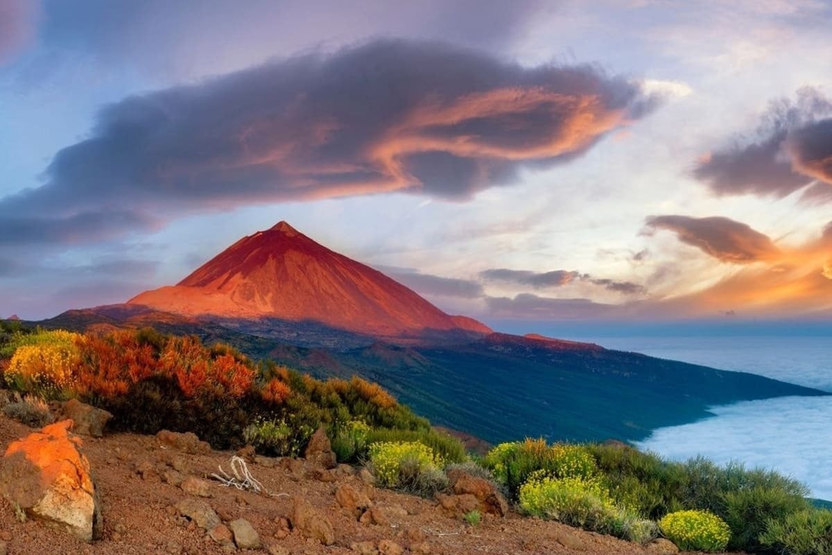 ein roter Vulkan sitzt über einer felsigen Landschaft