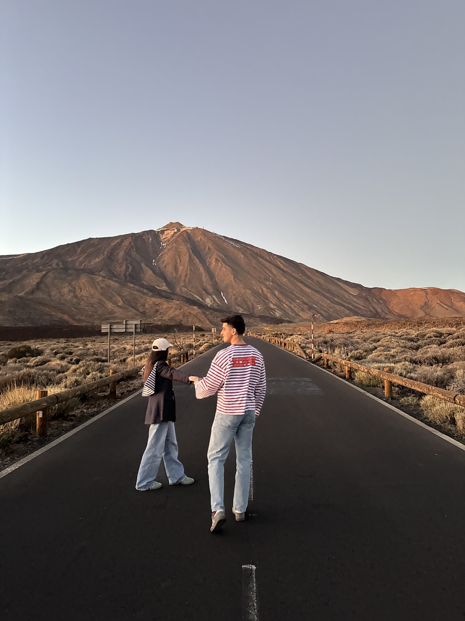 Couple marchant sur une route du parc national du Teide au coucher du soleil