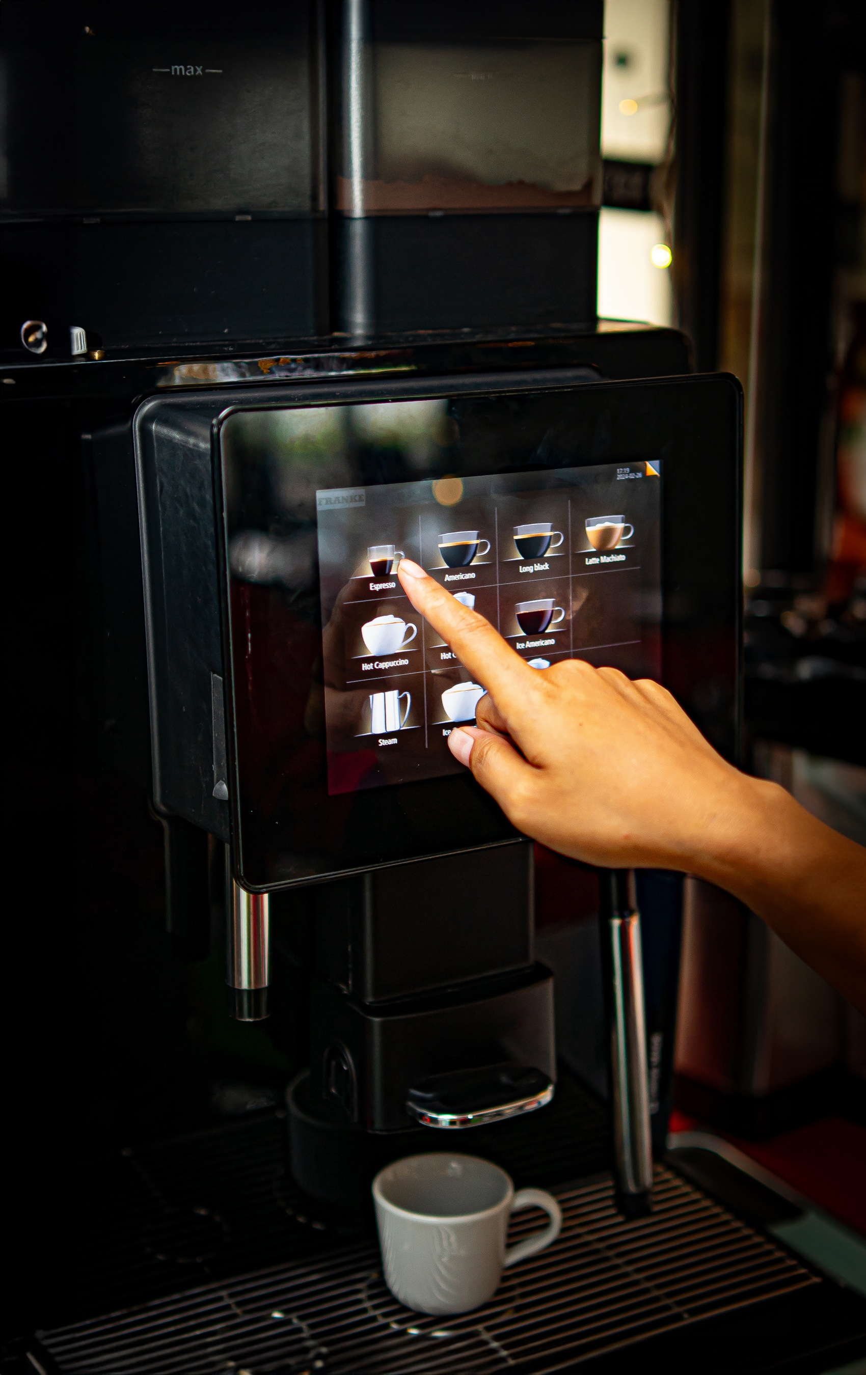 Landmar hotel guest using a modern coffee machine to select an espresso.