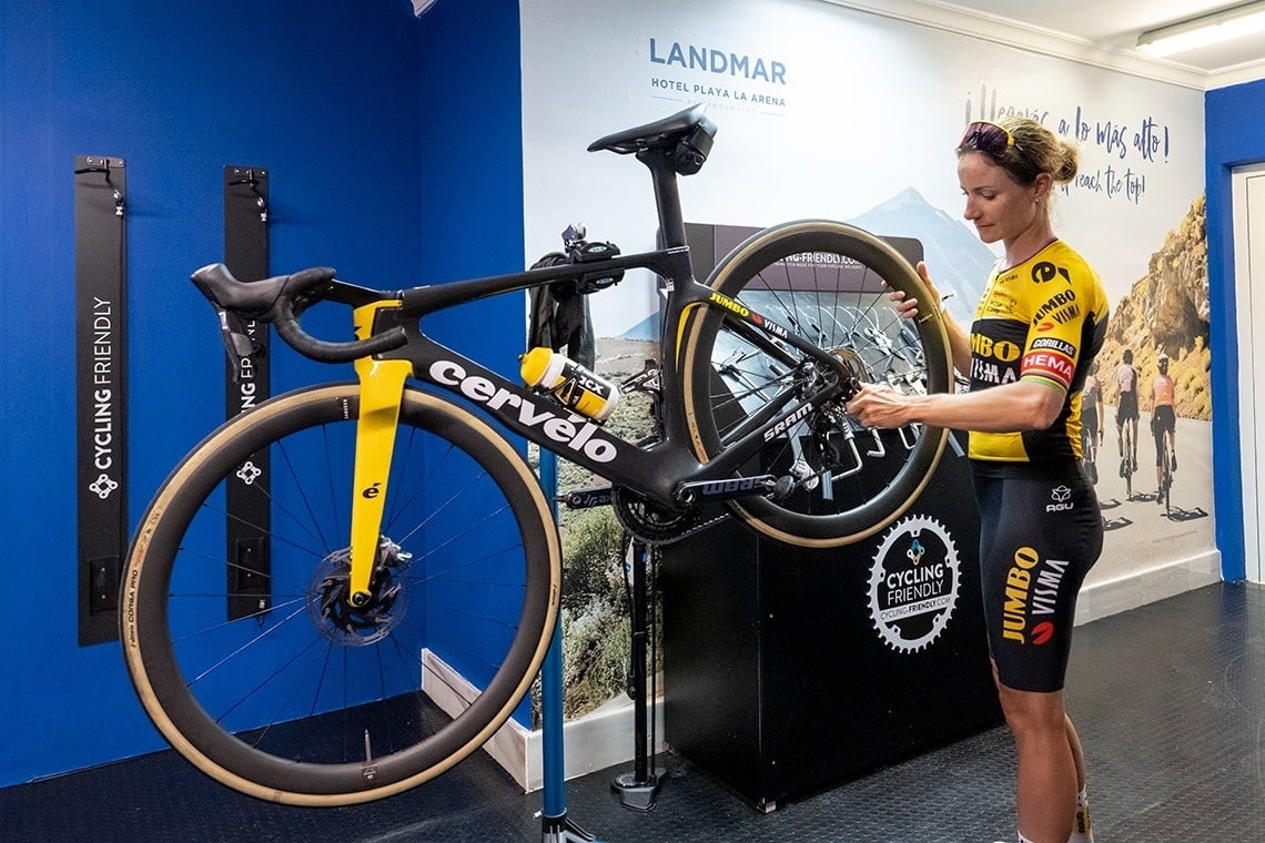 una mujer está reparando una bicicleta cervelo en un taller