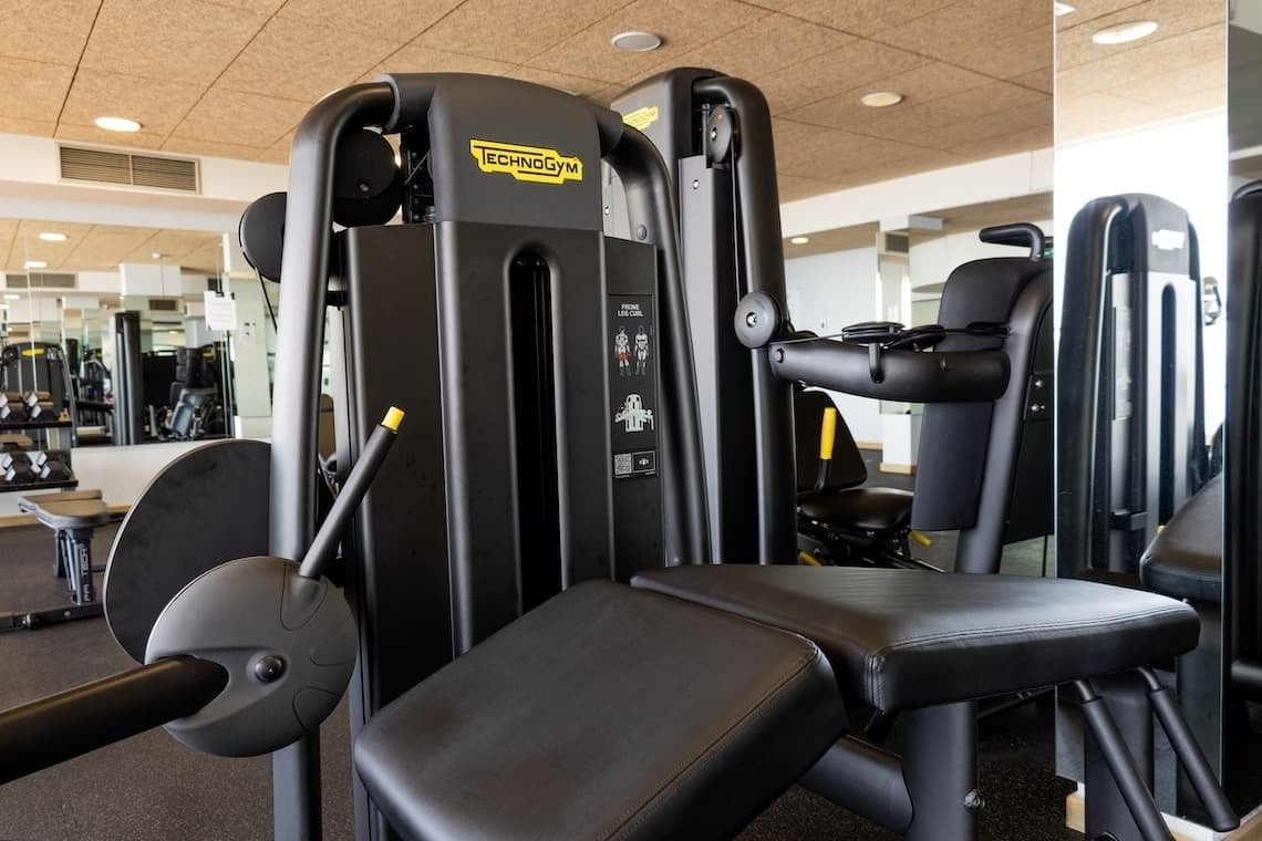 a black and yellow technogym machine in a gym