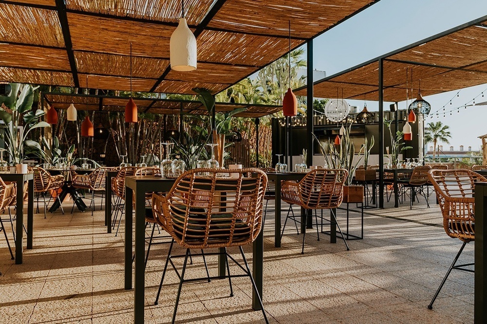 a restaurant with tables and chairs under a canopy