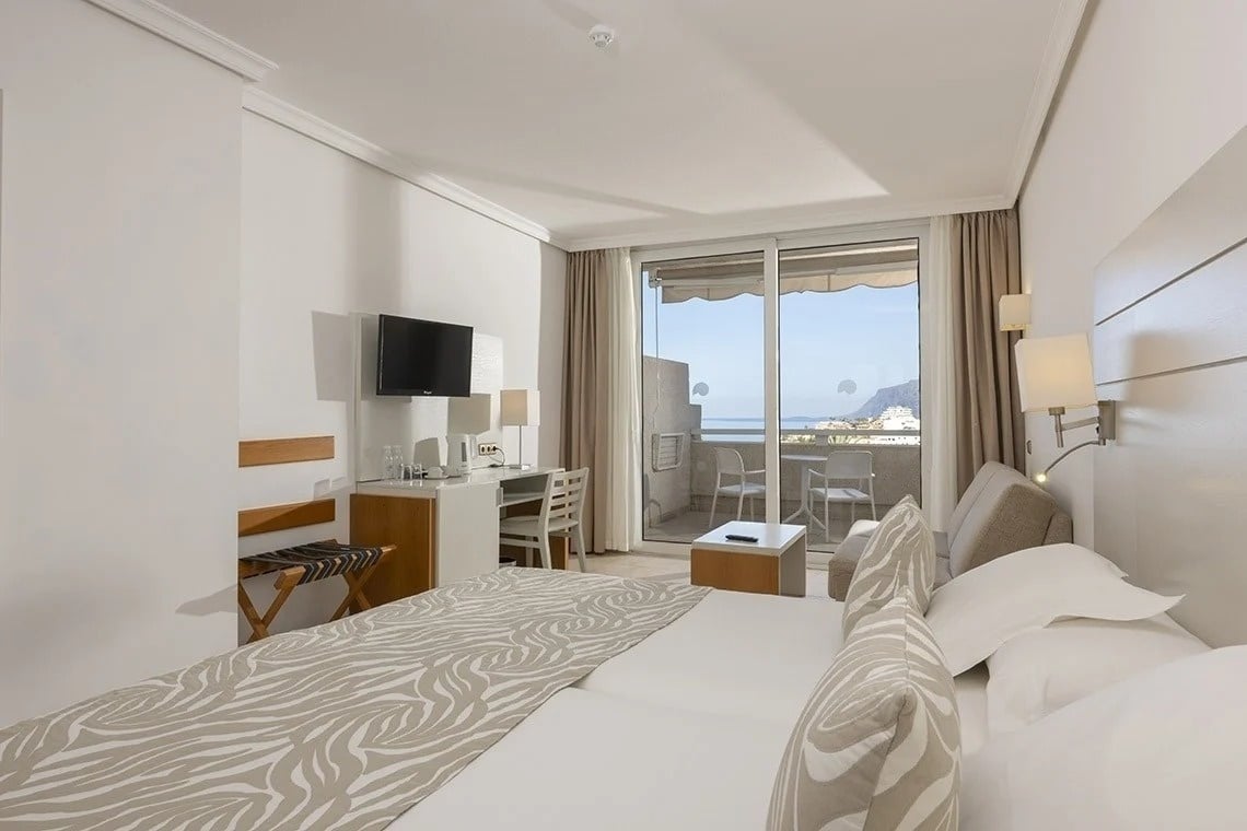 ein Hotelzimmer mit zwei Betten und einem Fernseher