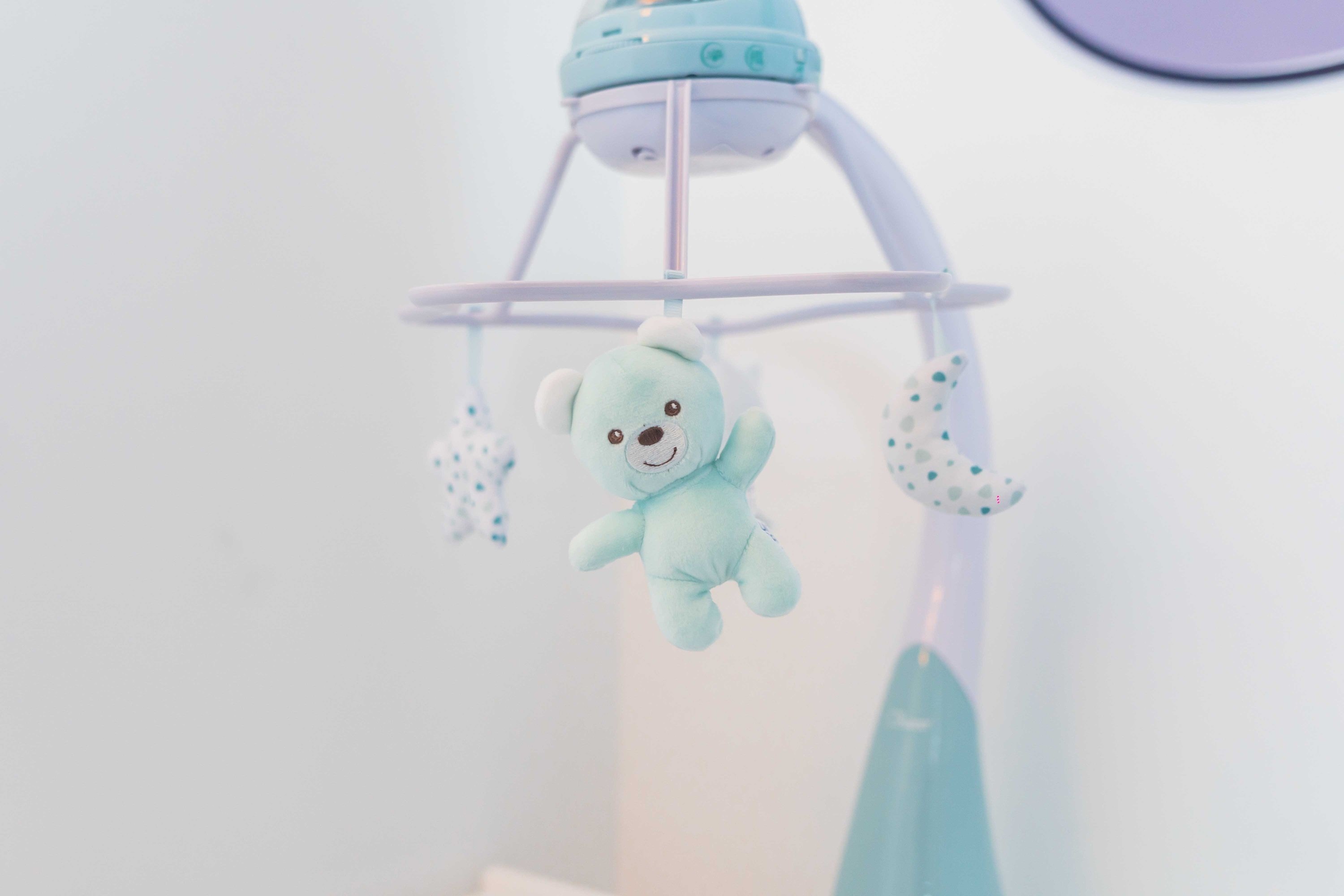 a baby mobile with a teddy bear hanging from it