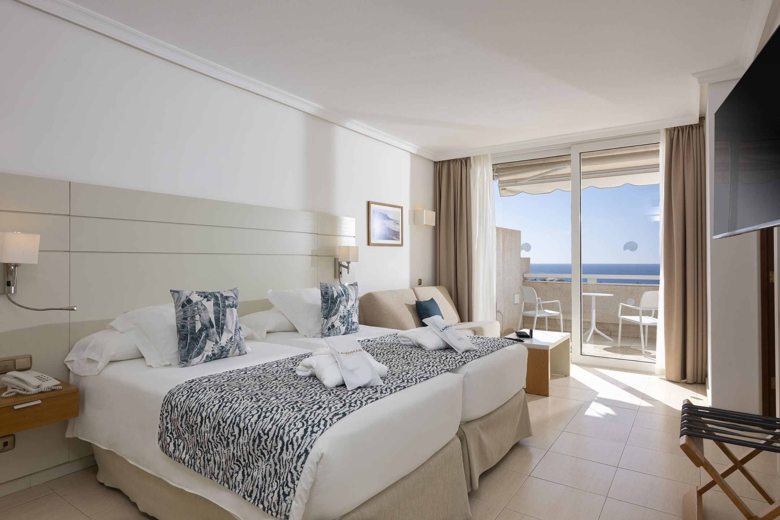 Habitación Landmar con dos camas, vista al mar y balcón.