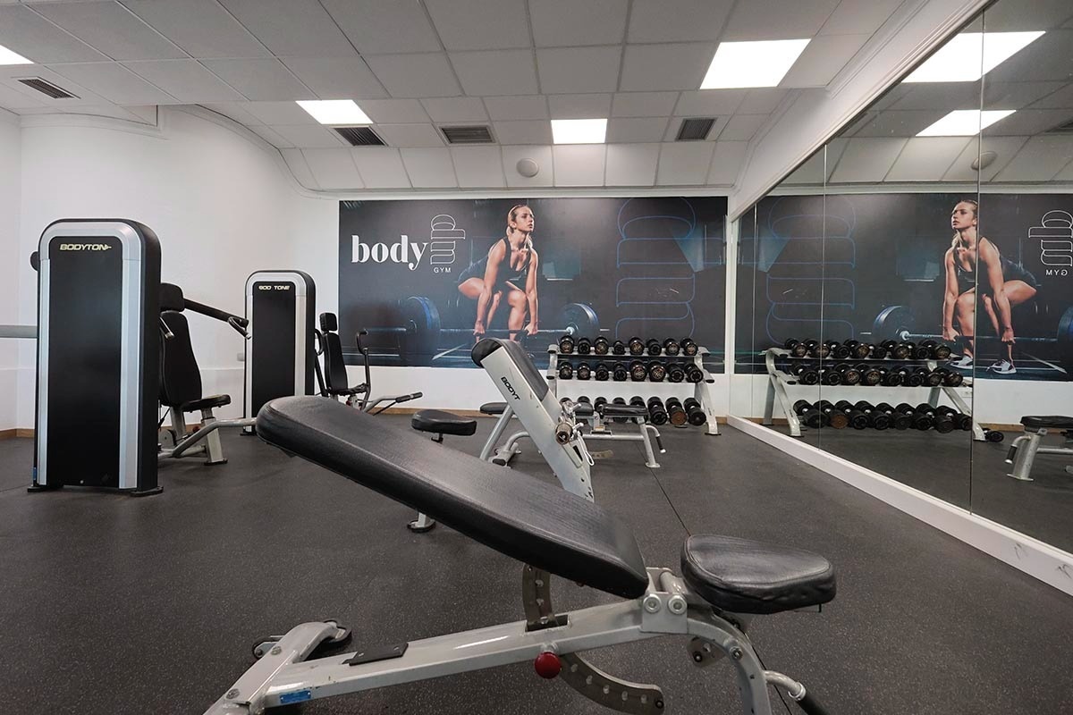 un gimnasio lleno de equipos de ejercicios y una máquina de ejercicios con la letra g encima