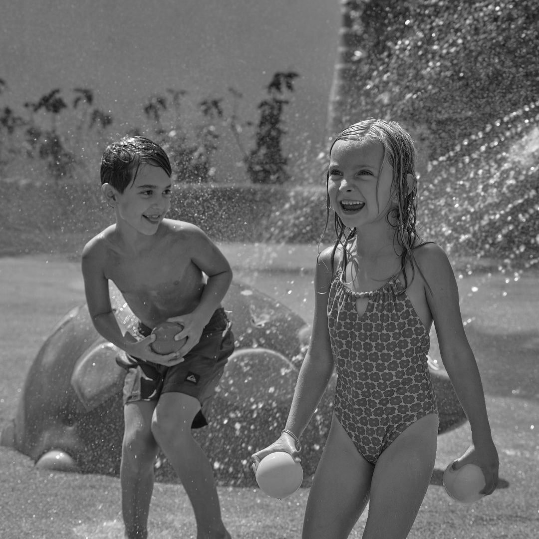 a young girl is sliding down a blue water slide