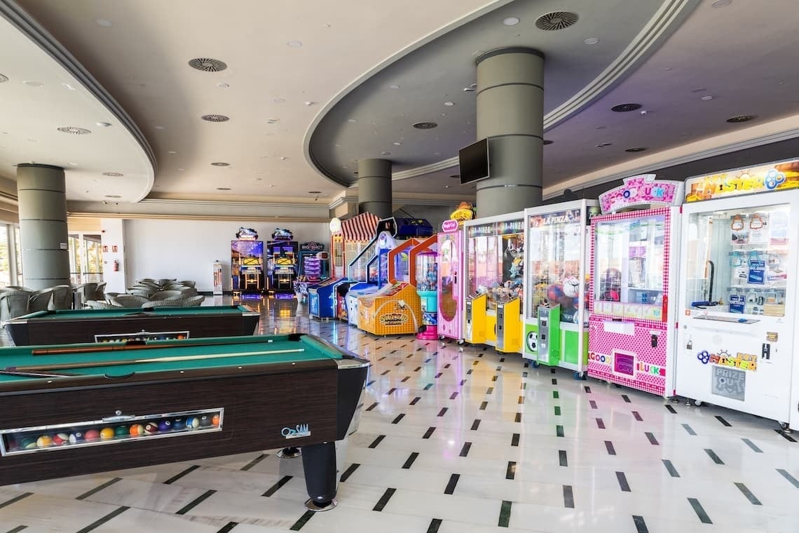 a pool table in a room filled with arcade games