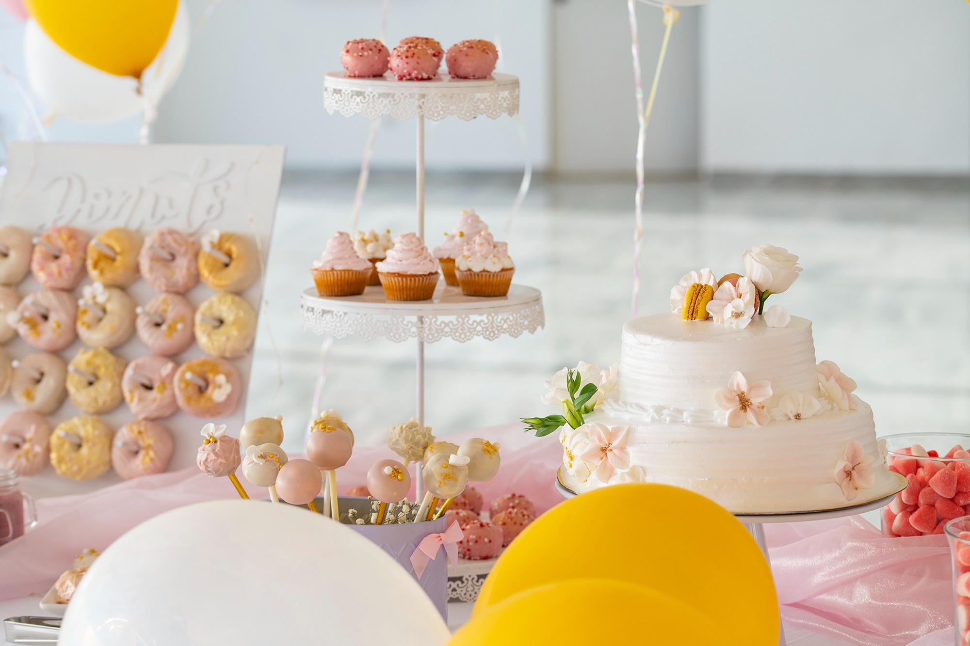 ein Desserttisch mit einer Hochzeitstorte und Cupcakes
