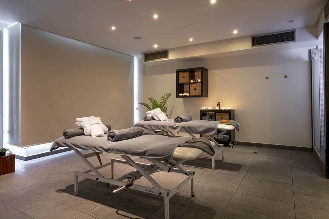 two massage tables with towels and candles in a room