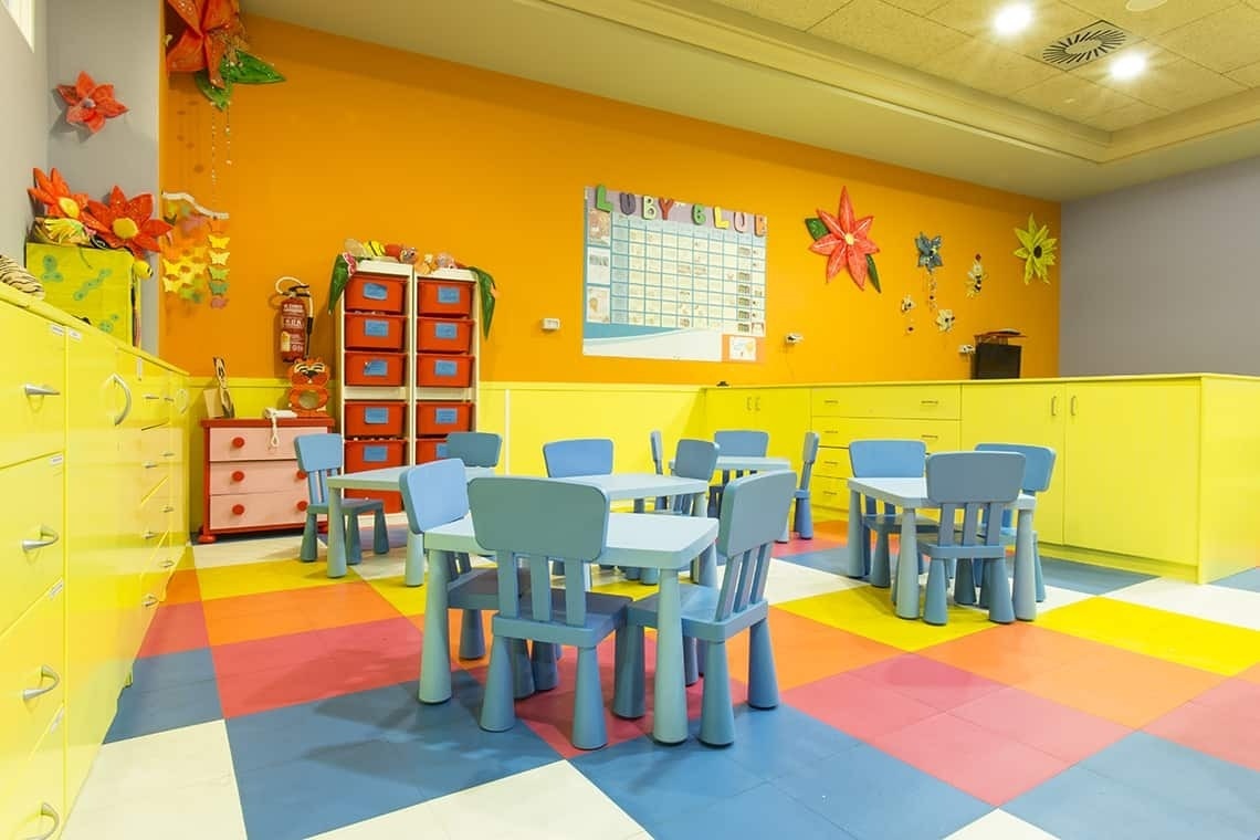 une salle de jeux colorée avec des tables et des chaises