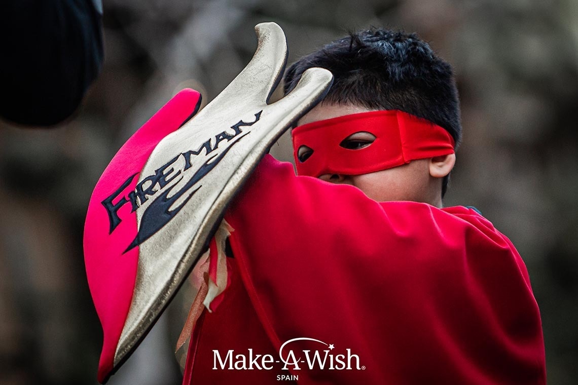 a boy in a fireman costume is holding a shield