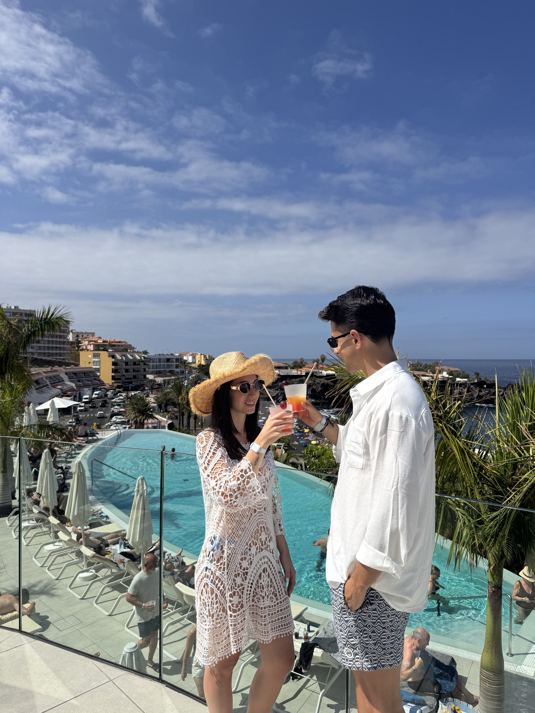 Couple trinquant avec un cocktail au bord de la piscine du Landmar Playa la Arena