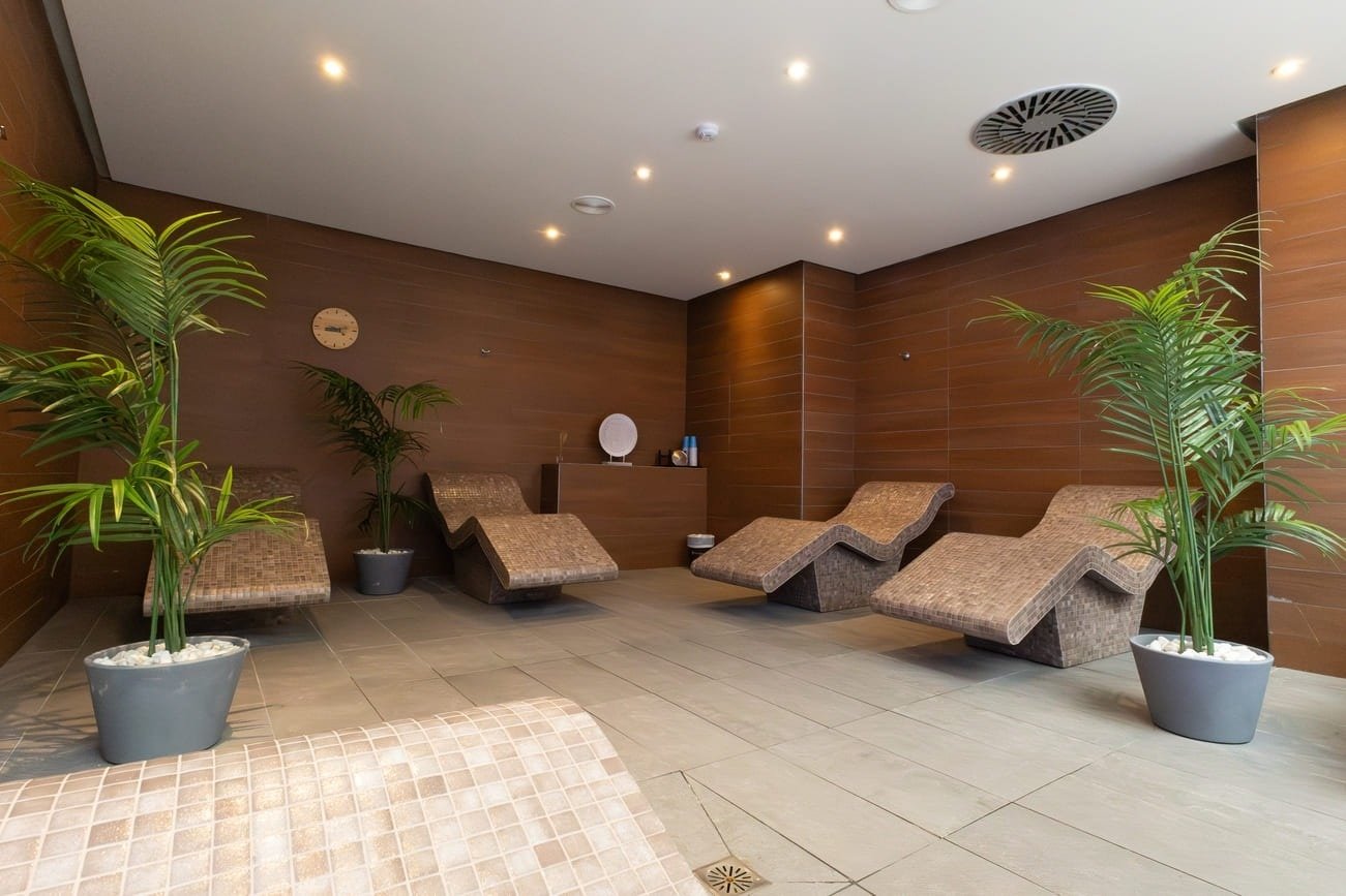 una sala de relajación con sillas y plantas en macetas