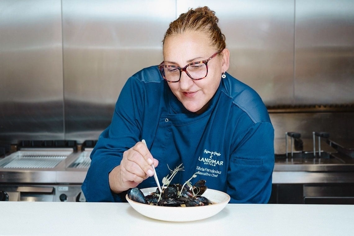 una mujer con una chaqueta azul con la palabra landmar en la parte delantera