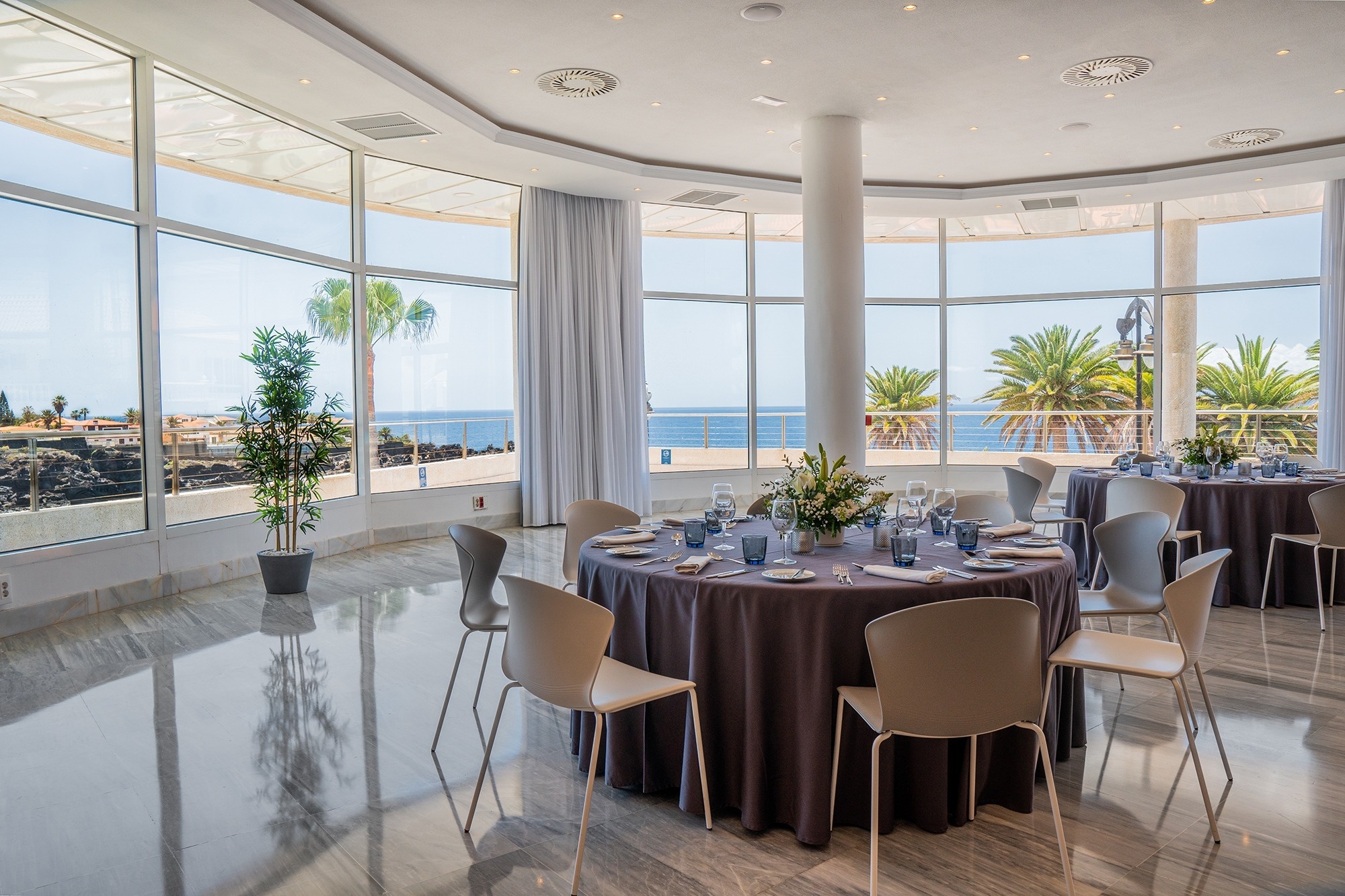 ein Tisch und Stühle in einem Raum mit vielen Fenstern