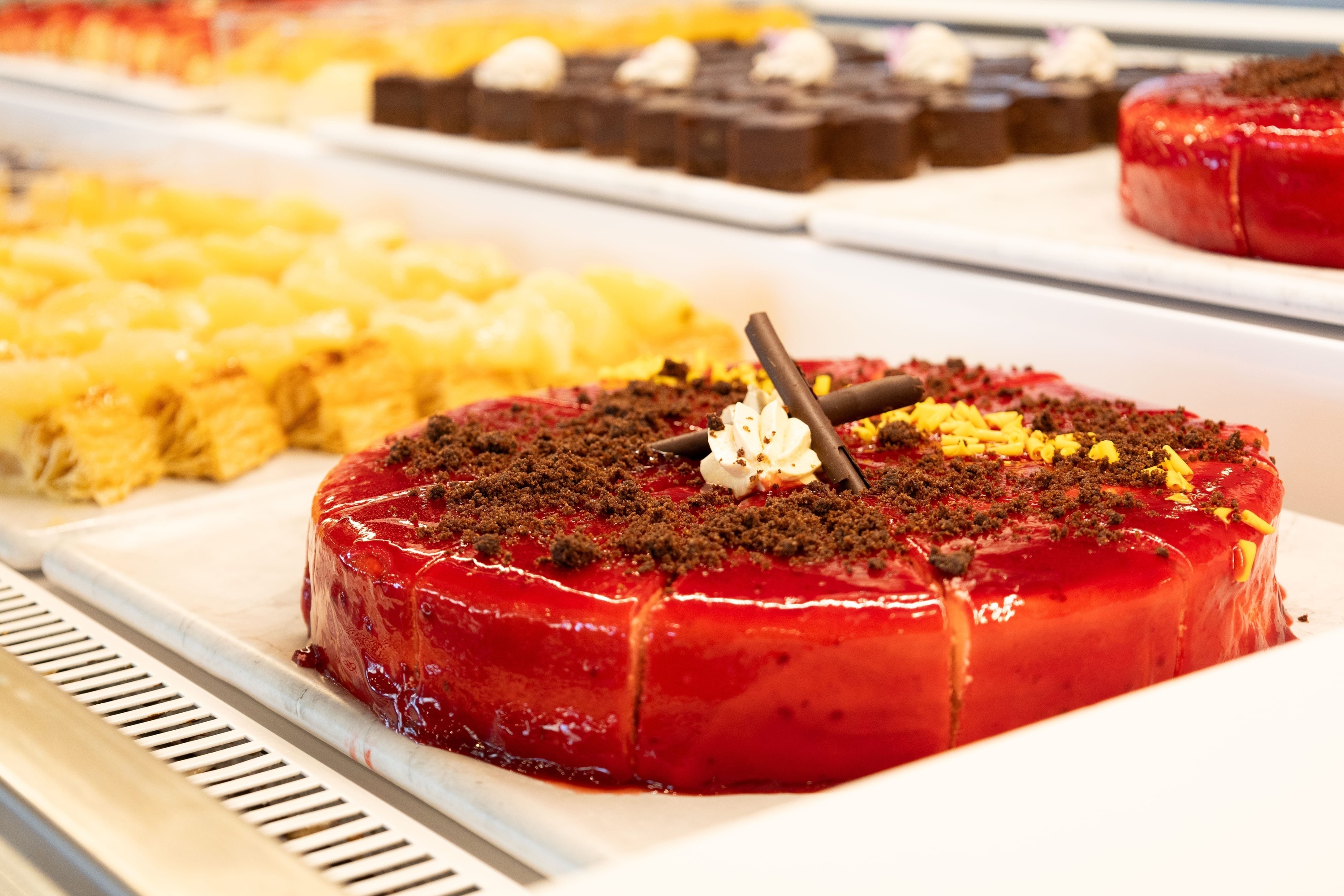 a red cake with chocolate crumbs and whipped cream on top