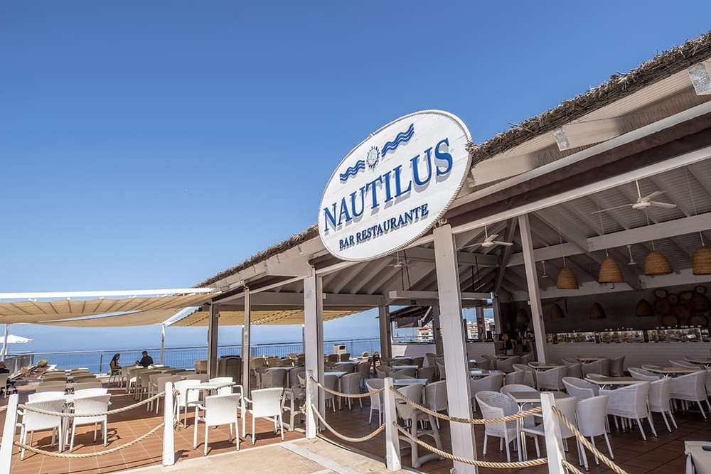 l' extérieur d' un restaurant nautilus avec des tables et des chaises