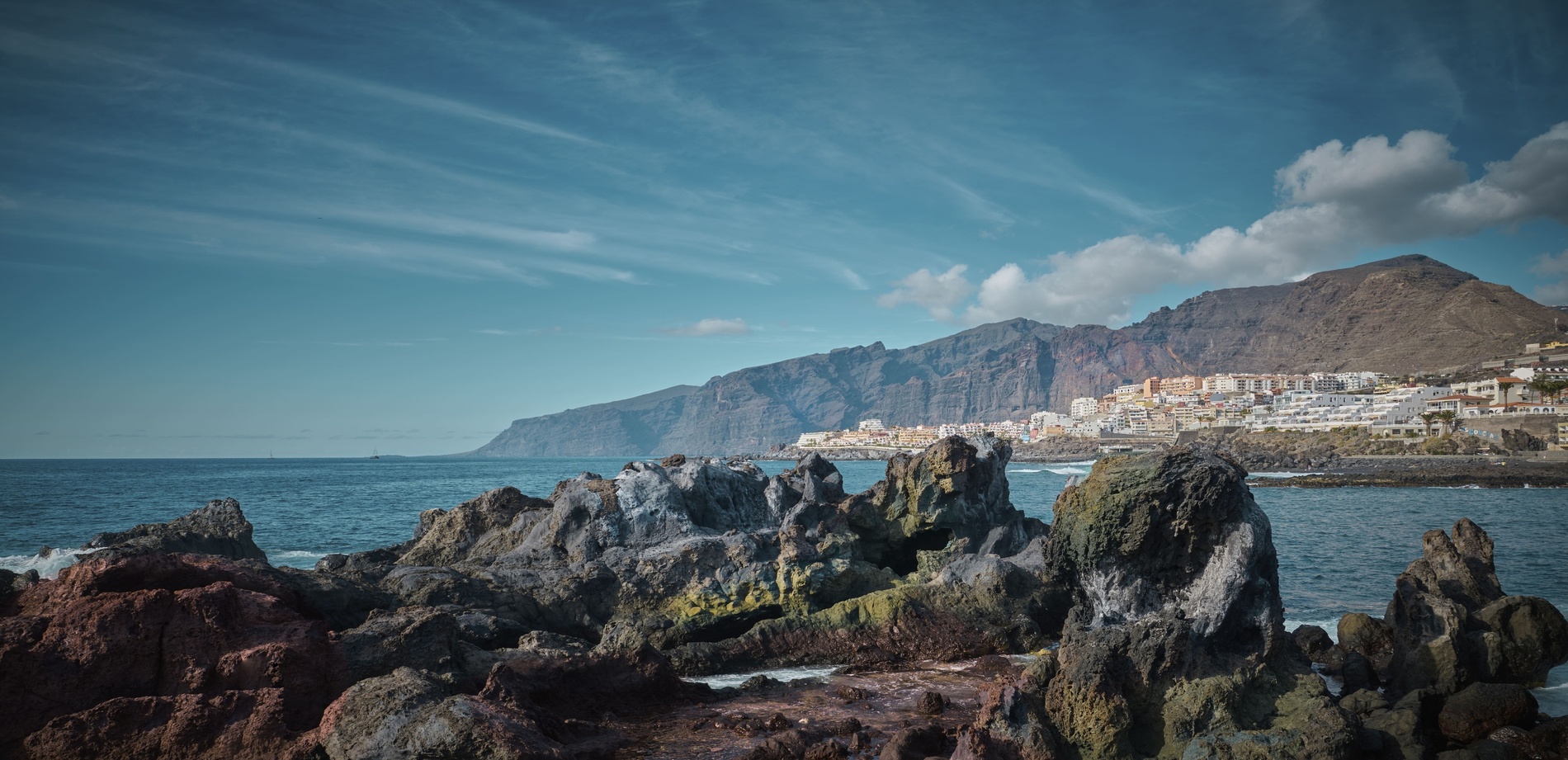 una vista aérea de una costa rocosa con edificios en la distancia