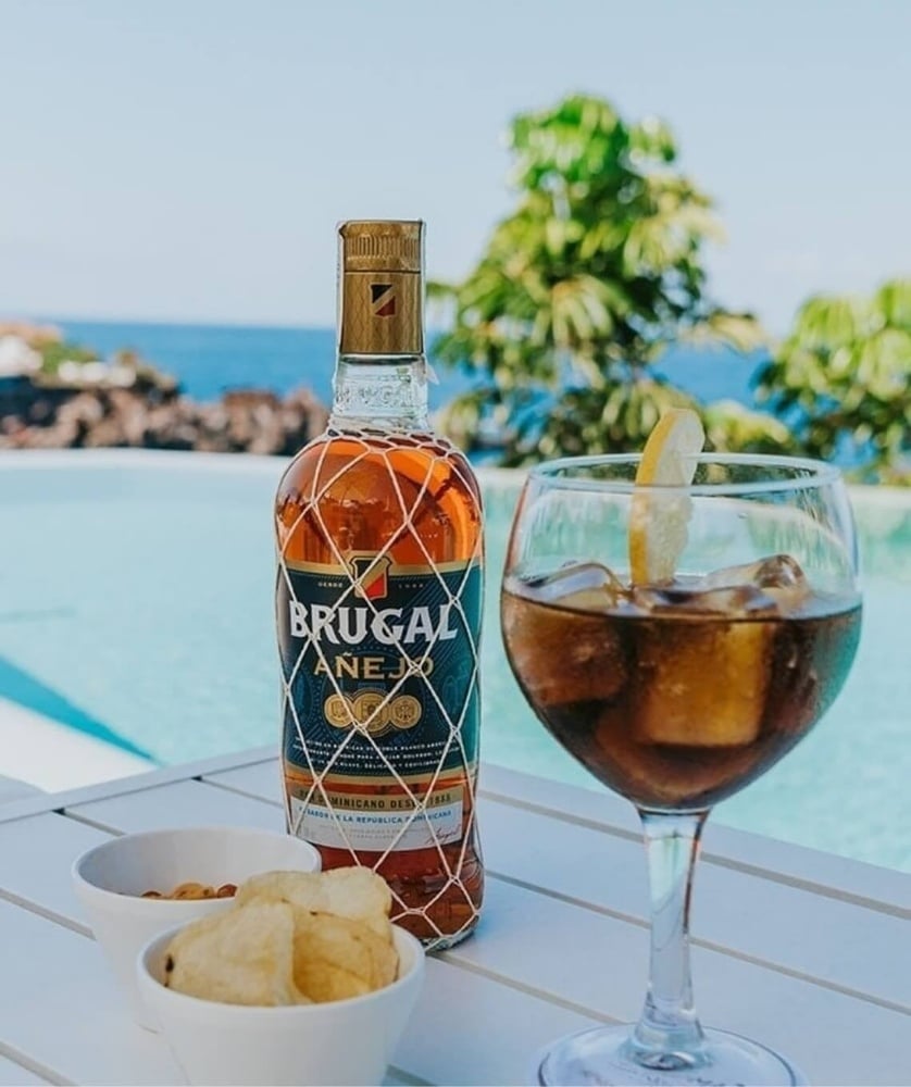 Savor Brugal Añejo by Landmar's pool, with ocean views.