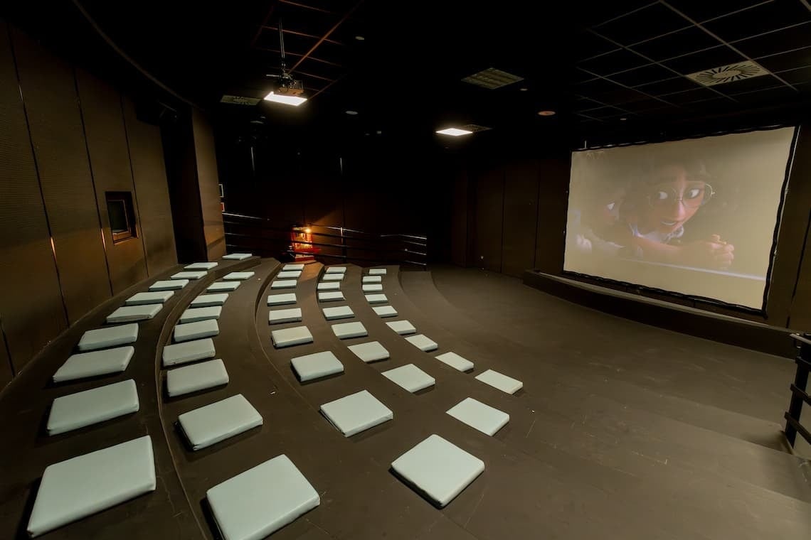 a group of people on a stage with a large screen behind them