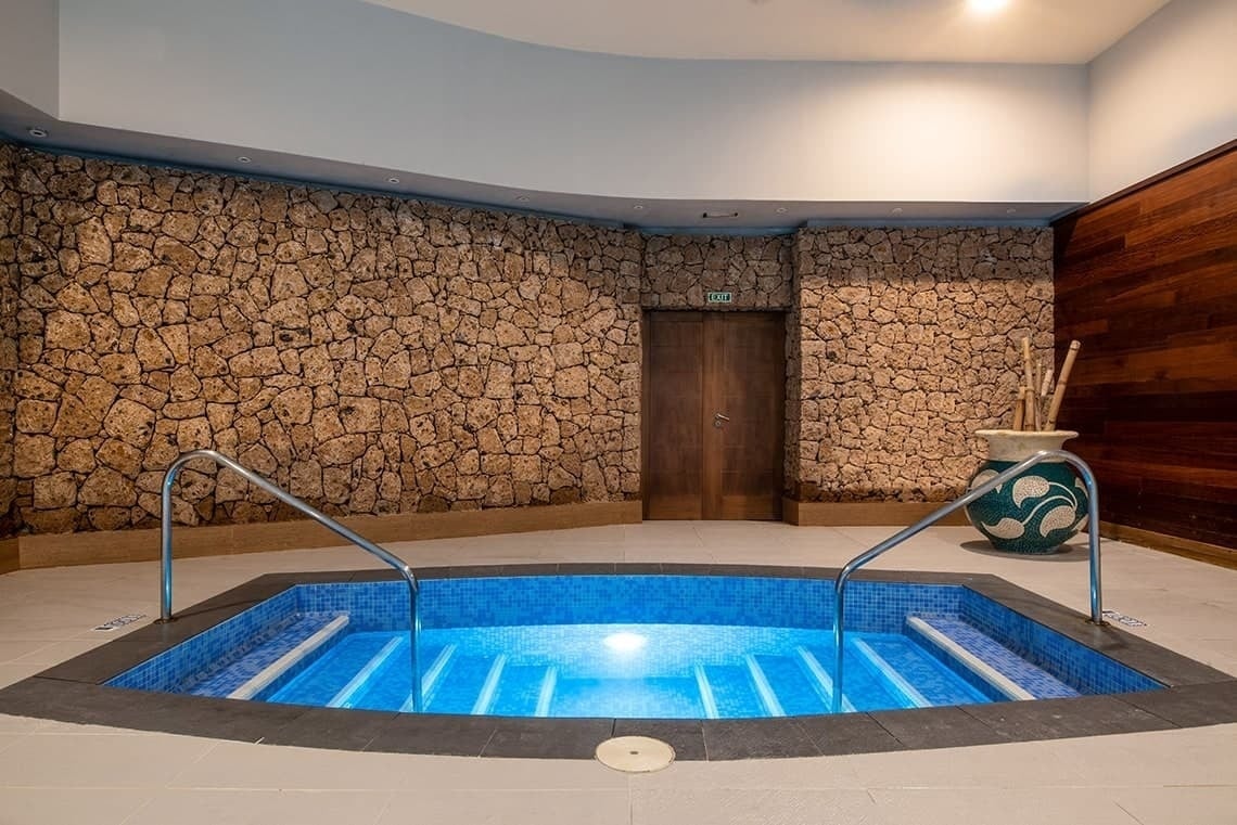 a swimming pool with a green exit sign above it