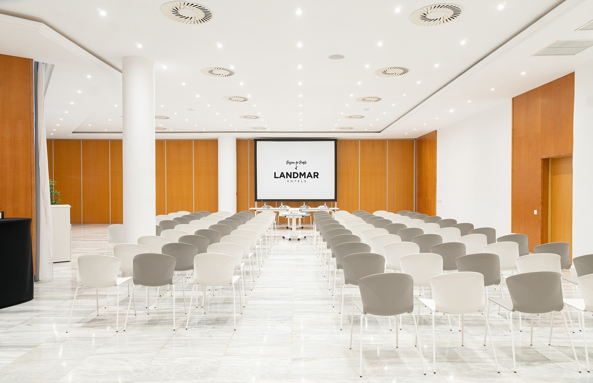 ein großer Raum mit vielen Stühlen und einem großen Bildschirm mit der Aufschrift landmar
